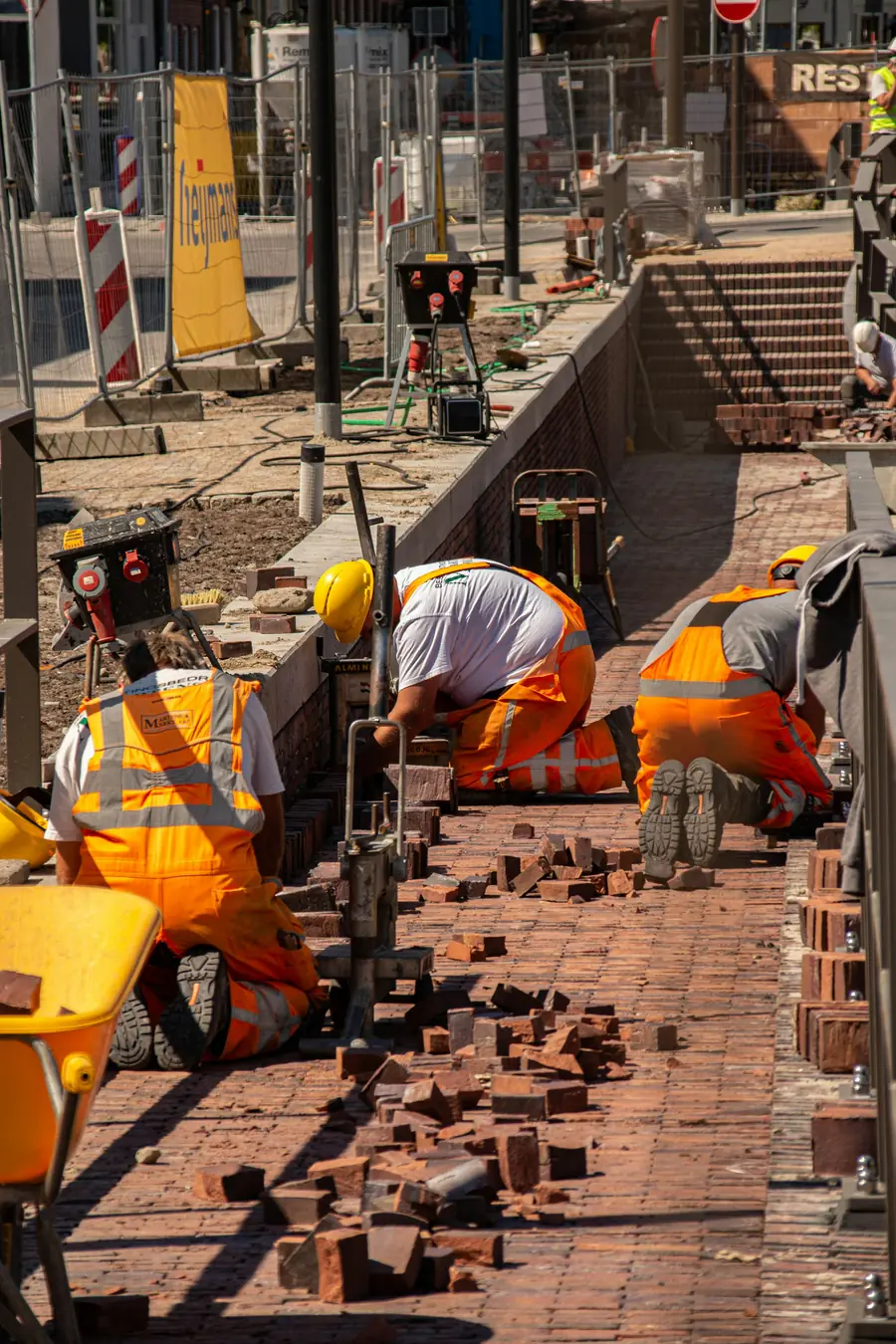 Masonry crew laying a brick walkway on a residential site