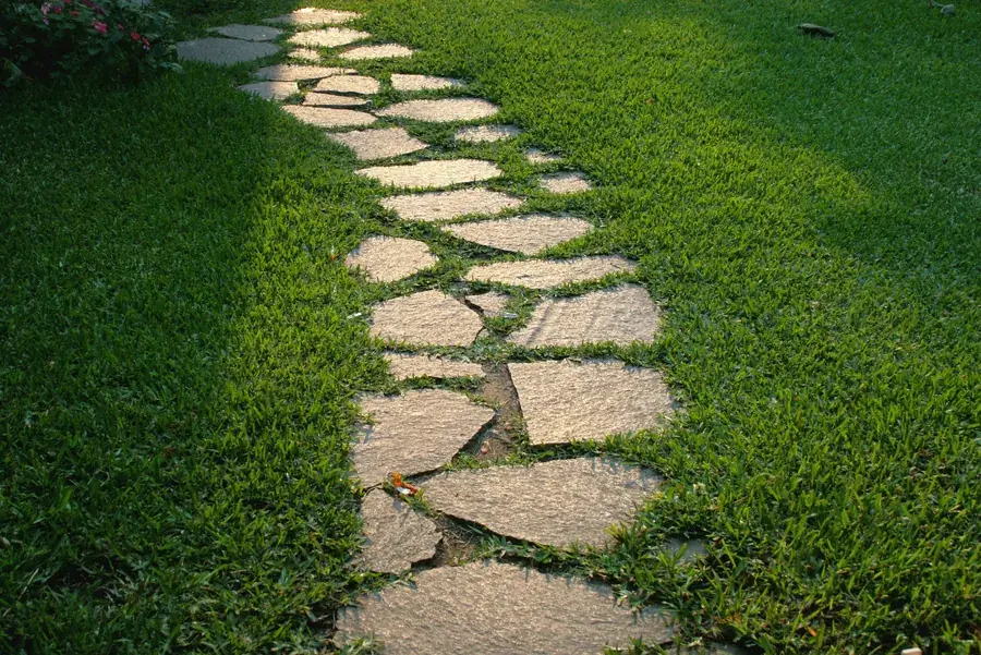 Irregular natural flagstone path set into a lawn